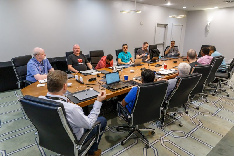 Wide view of a working session around a long boardroom table