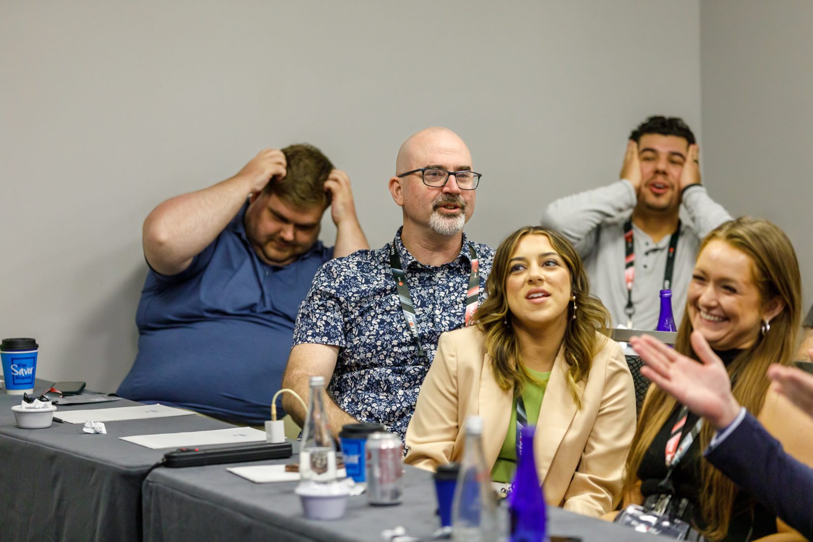 Attendees laughing together at a table during a breakout session