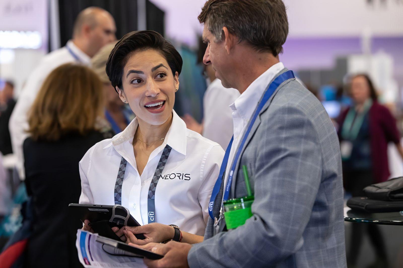 Exhibitor with a tablet talking with a visitor on the show floor