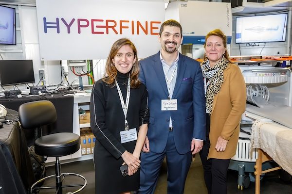 Three exhibitors posing in their trade show booth