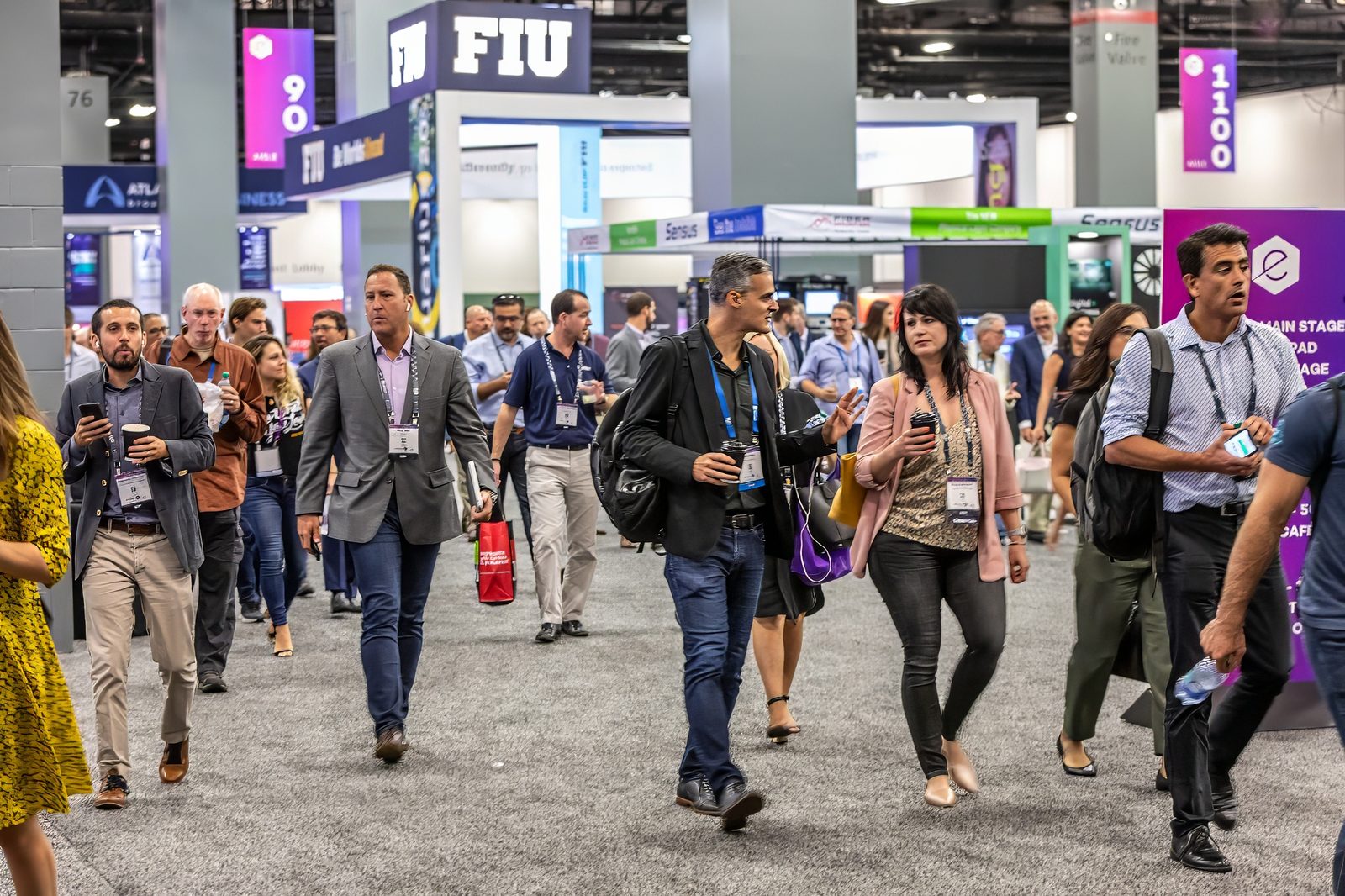 Attendees walking a busy convention aisle