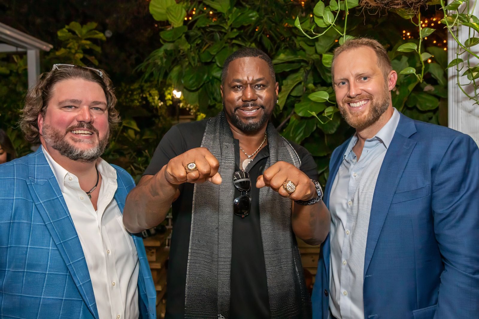 Three guests posing at an evening garden reception