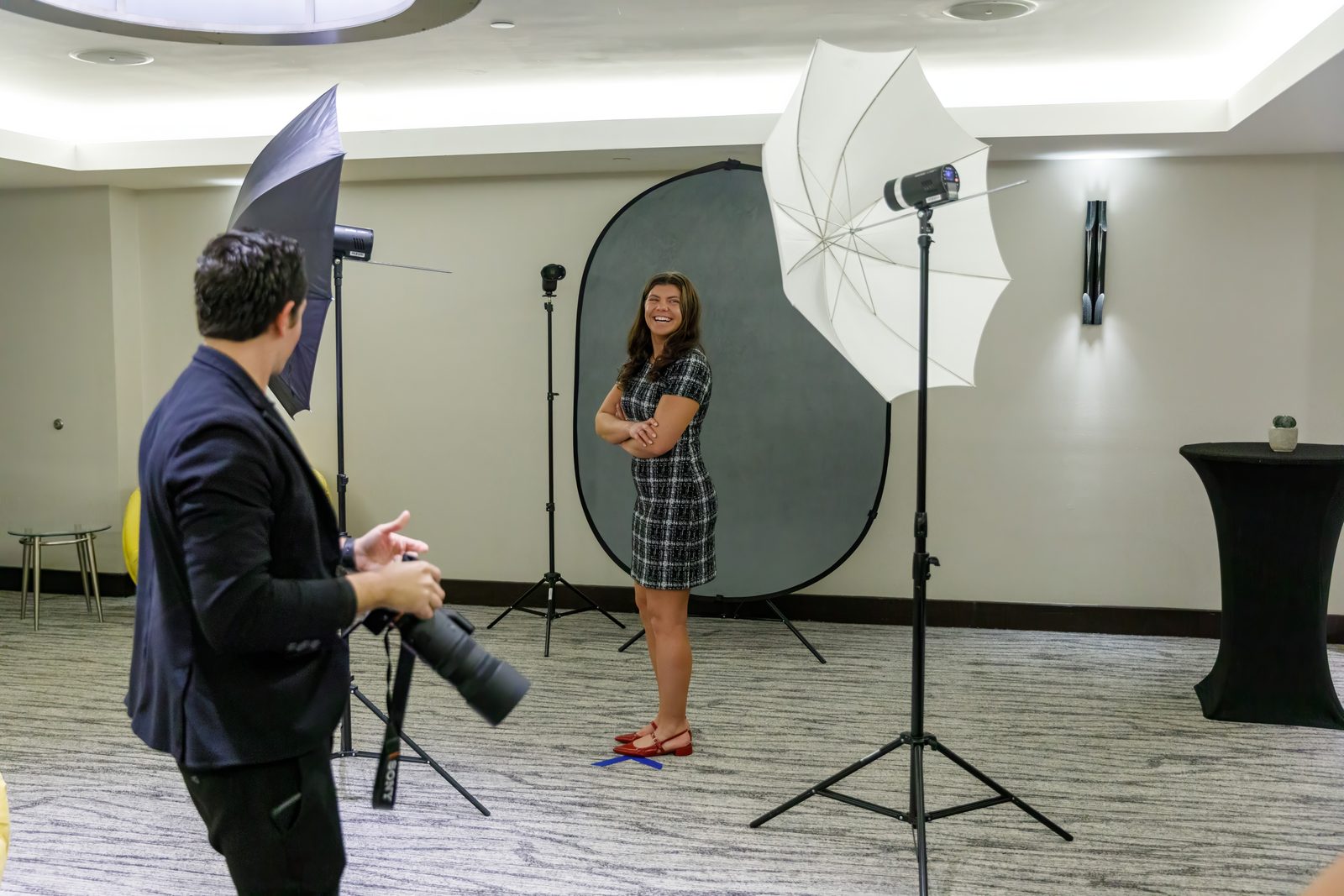 Photographer shooting an attendee at a lit headshot station set up in a conference venue