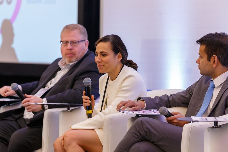 Panelist speaking into a microphone between two other panelists