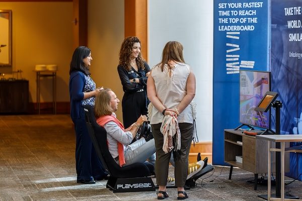Attendees watching a racing simulator demo at a brand activation