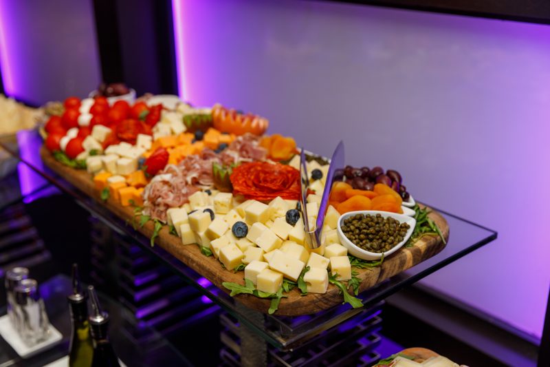 Charcuterie and cheese display on a glass stand at the welcome reception