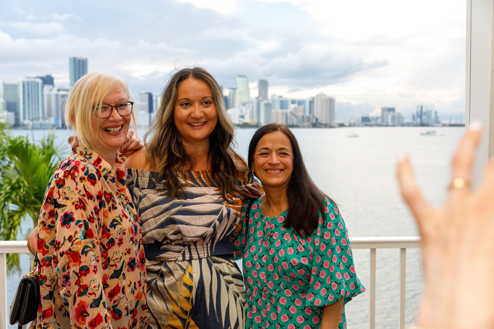 Three guests smiling at a waterfront reception