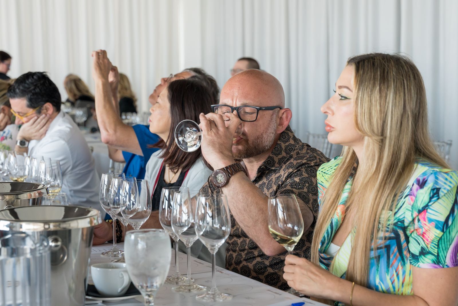Guests tasting wine at a long table during a hosted tasting session